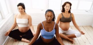 Three pregnant women meditating.