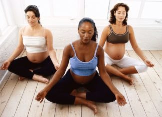 Three pregnant women meditating.