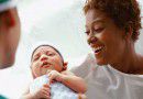 A doctor handing a mum her newborn baby