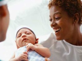 A doctor handing a mum her newborn baby