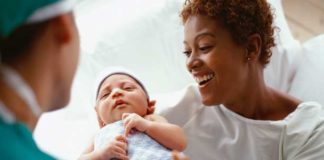A doctor handing a mum her newborn baby