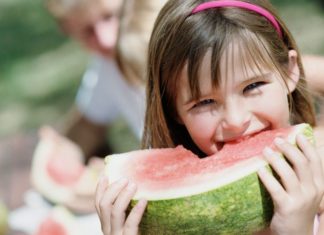 Girl biting into watermelon