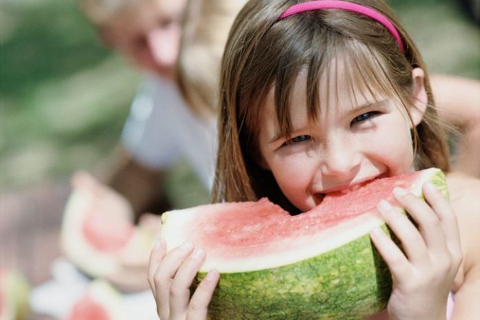 Girl biting into watermelon