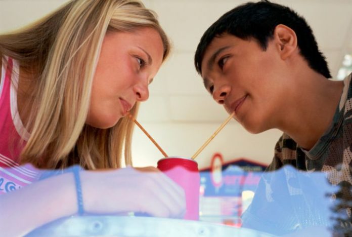 Teen couple sharing a drink