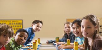 Students eating lunch in cafeteria, portrait.