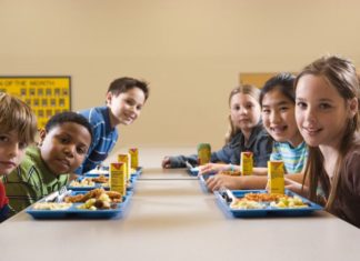 Students eating lunch in cafeteria, portrait.