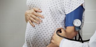 A pregnant woman has her blood pressure taken.