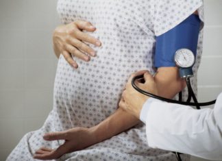 A pregnant woman has her blood pressure taken.