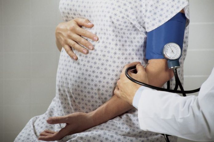 A pregnant woman has her blood pressure taken.