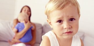 Unhappy toddler with mother and sibling.