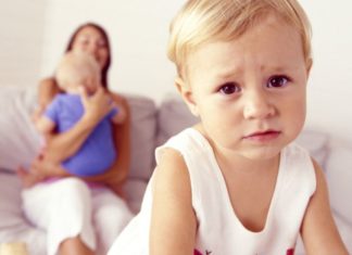 Unhappy toddler with mother and sibling.