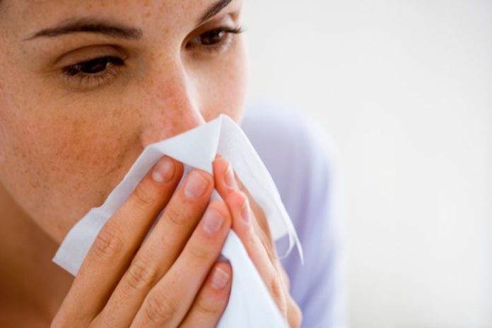 Woman blowing nose.