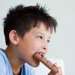 Boy eating chocolate bar