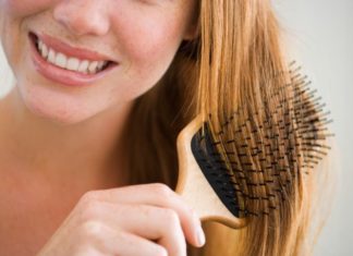 Woman brushing hair with paddle brush