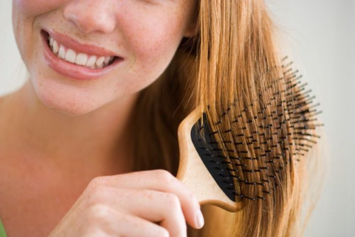 Woman brushing hair with paddle brush