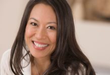 A happy portrait of a young woman with long dark hair.