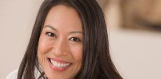 A happy portrait of a young woman with long dark hair.