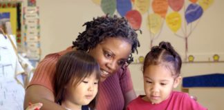 Childcare teacher colors with two little girls.