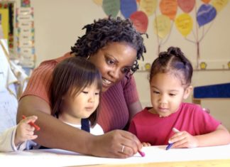 Childcare teacher colors with two little girls.