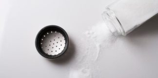 Salt poured from shaker onto table