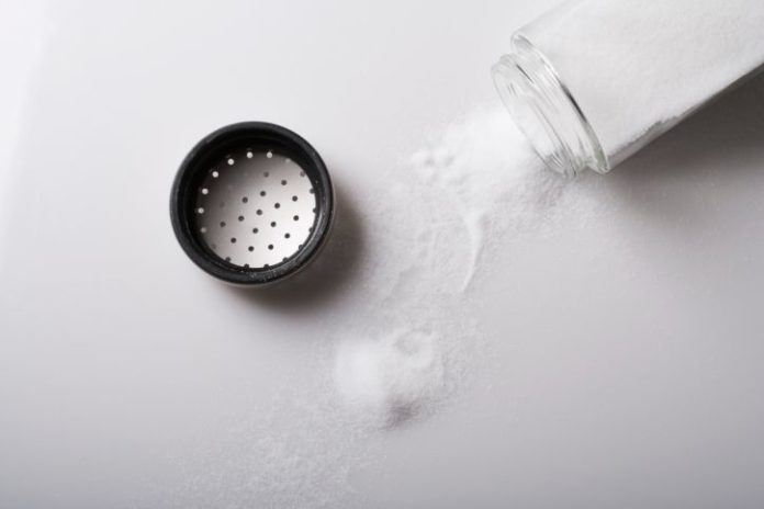 Salt poured from shaker onto table