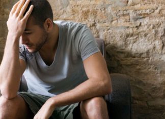 Man holds his head in his hands.