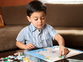 Boy putting puzzle together