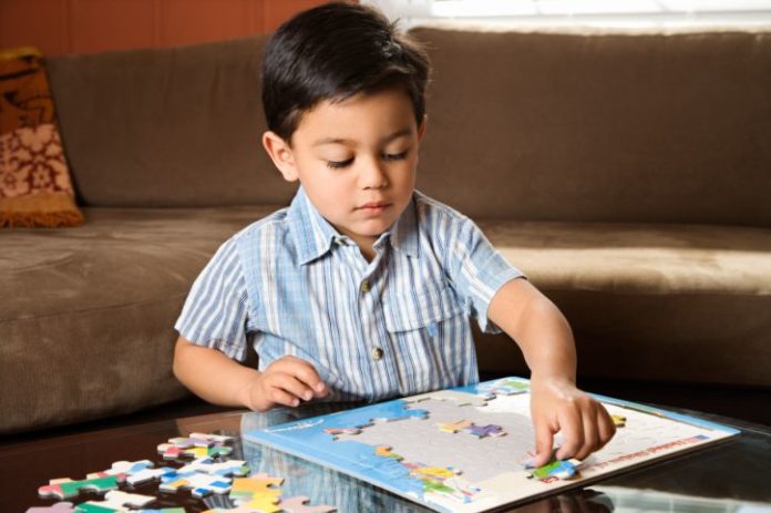 Boy putting puzzle together