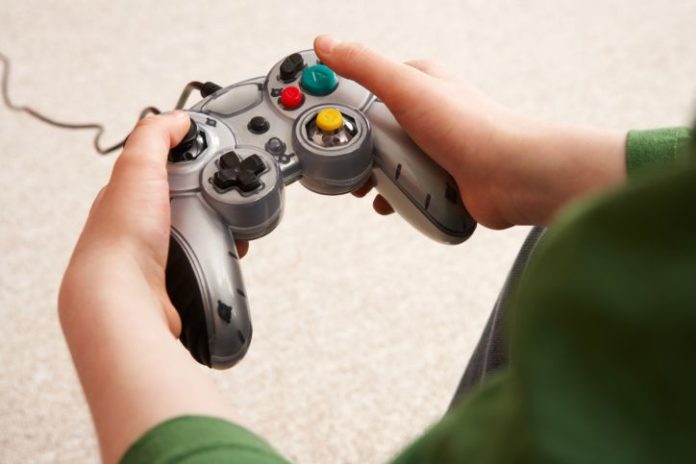 A boy's hands on a video game controller.