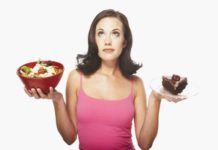 Woman balancing food. In one hand is a salad and in the other, a large piece of chocolate cake.