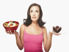 Woman balancing food. In one hand is a salad and in the other, a large piece of chocolate cake.