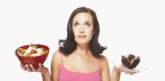 Woman balancing food. In one hand is a salad and in the other, a large piece of chocolate cake.