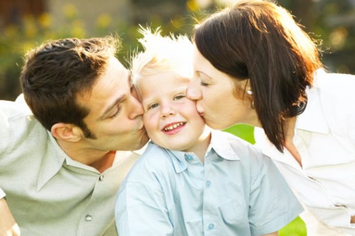 Parents kissing son