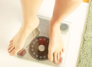 A view of a person's feet as they stand on a scale.