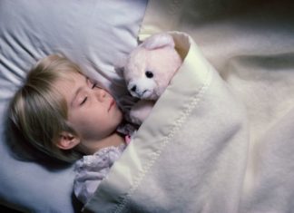 Boy sleeping with teddy