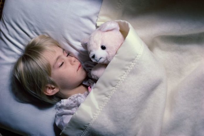 Boy sleeping with teddy