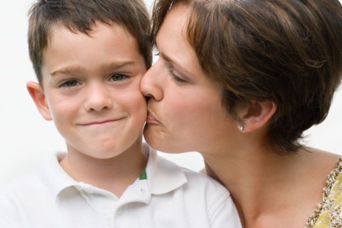 Mother kissing son