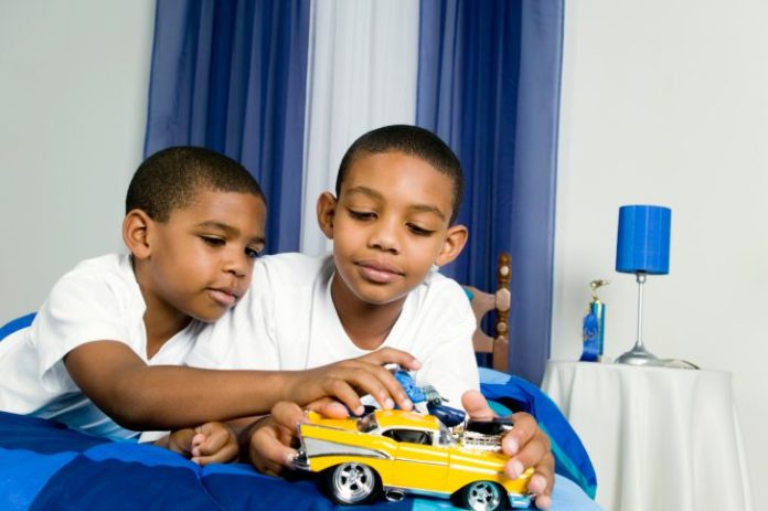 Brothers playing with toy car
