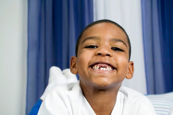 Portrait of smiling boy with missing front teeth.