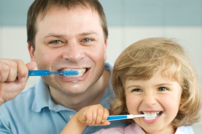 Dad and daughter brushing teeth