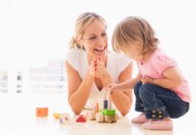 Mother and daughter indoors playing and smiling