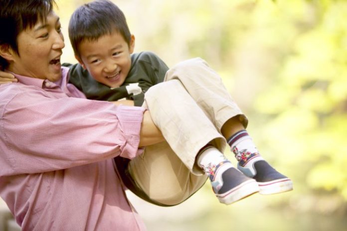 Dad and son playing outdoors.