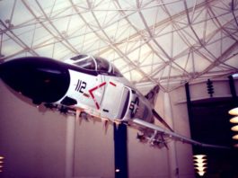 An airplane indoors, hanging from the rafters.