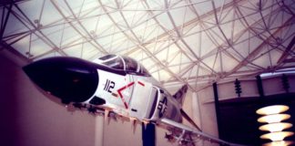 An airplane indoors, hanging from the rafters.