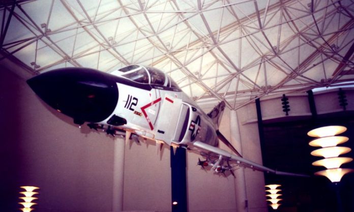 An airplane indoors, hanging from the rafters.