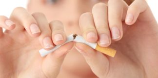 Young woman breaking a cigarette in half.