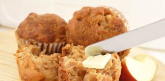 Tasty looking apple bran muffins being spread with butter.