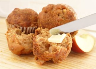 Tasty looking apple bran muffins being spread with butter.
