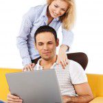 Happy couple on sofa with laptop computer