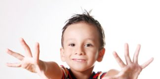 Smiling boy holding out hands, as if to say - "look! they're clean!